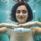 Woman holding a bottle of purify barrier repair cream by avry1 pretty under water